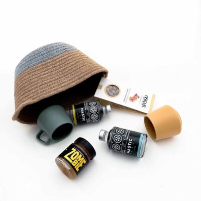 Basket with two mastic liqueurs, two ceramic mugs, zombie cocktail flavor jam, caramelized peanuts